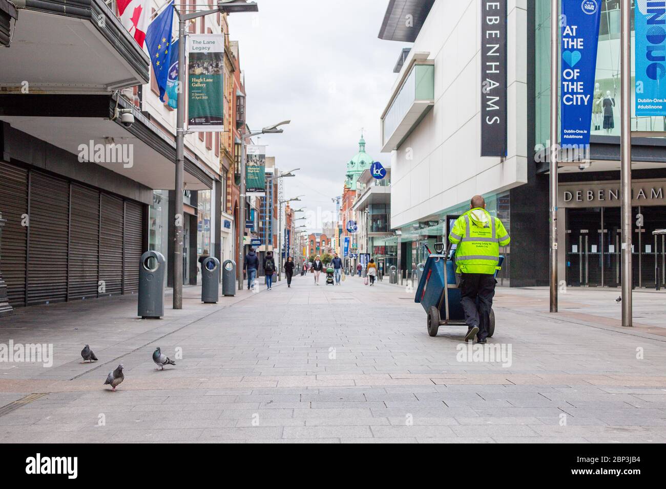 Straßenarbeiter des County Council geht durch die verlassene Henry Street in Dublin, Irland, während der Fußabsturz aufgrund der Coronavirus-Pandemie abstürzt. Stockfoto