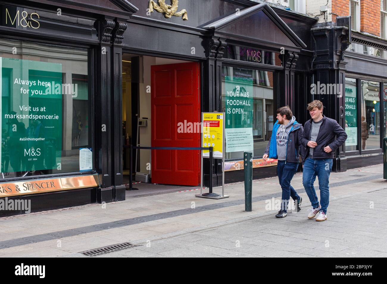 Zwei Männer gehen am eingeschränkten Zugang zum Marks & Spencer Store in der Grafton Street im Stadtzentrum von Dublin vorbei. Sicherheitsmaßnahmen für Einzelhandelsgeschäfte Covid-19. Stockfoto