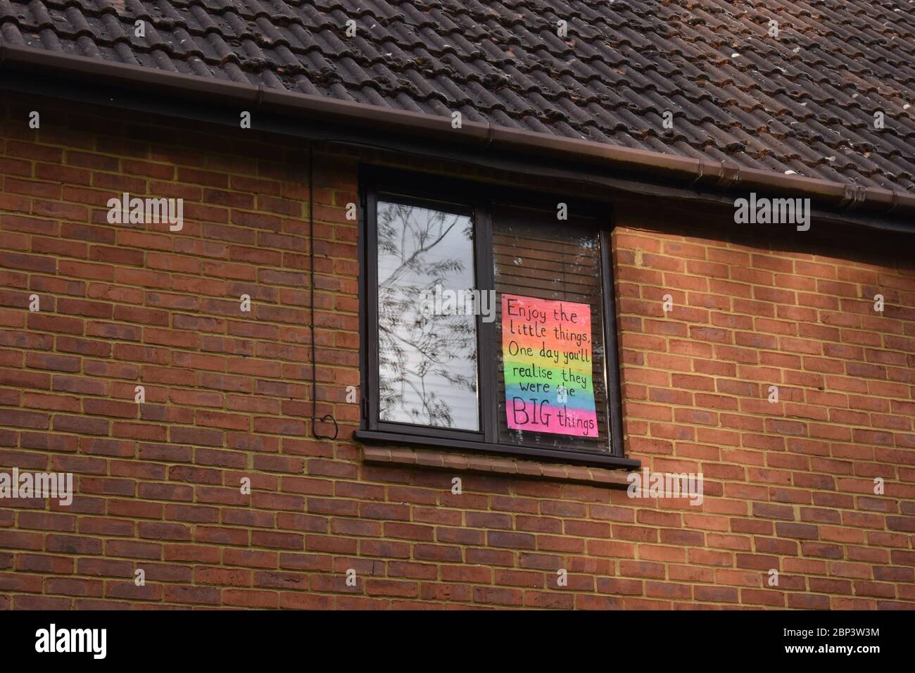 Ein Poster auf einem Haus in Milton Keynes - genießen Sie die kleinen Dinge auf einem Regenbogen. Eine optimistische Reaktion auf Covid-19. Stockfoto