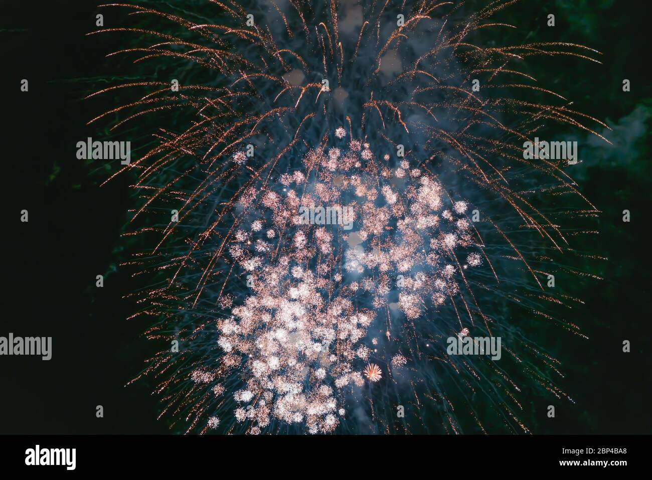 Blau-weißes Feuerwerk mit Rauch über dem schwarzen Himmel. Geringe Tastenbelichtung. Selektiver Fokus. Stockfoto