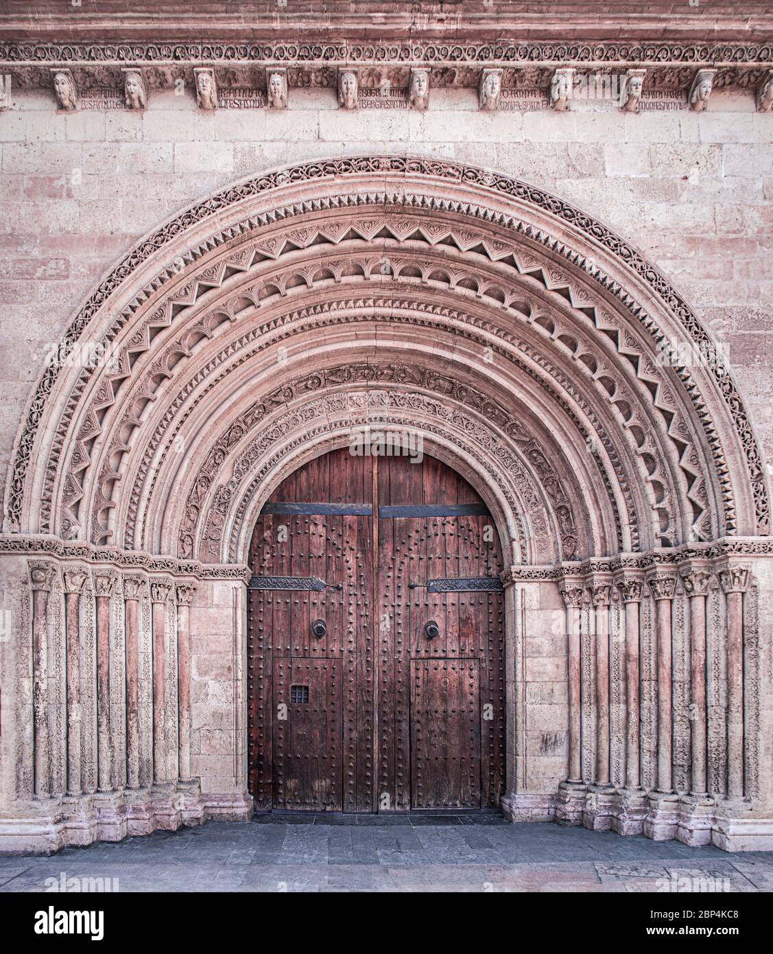 Fassade mit Tür in einer gewölbten Öffnung, die mit Mustern und Ornamenten verziert ist. Gotische Architektur, Valencia, Spanien, April 2019 Stockfoto