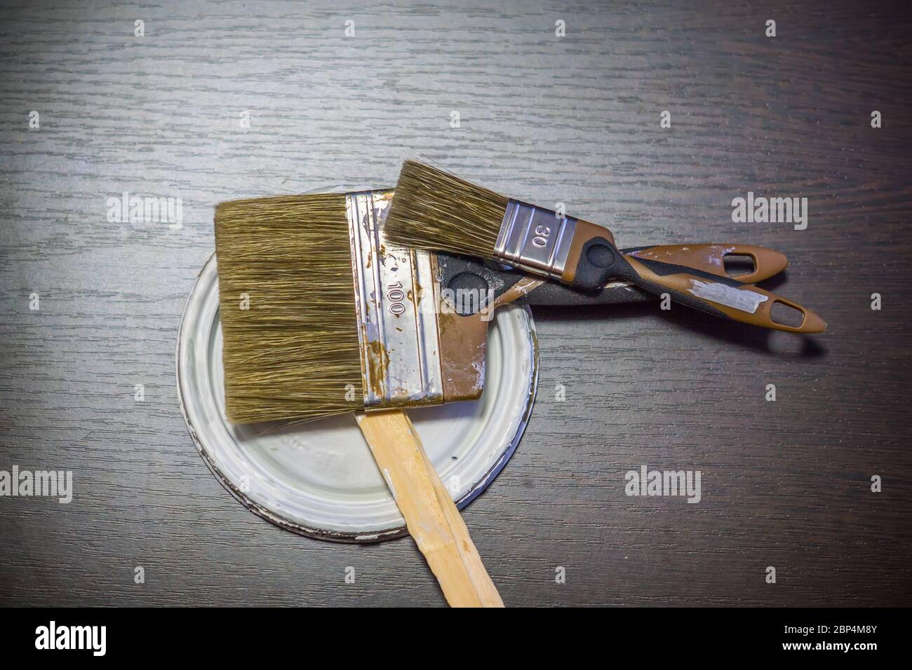 Zwei schmutzige gebrauchte Pinsel auf Holzhintergrund Stockfoto