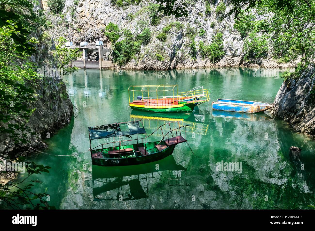 Alte schroffe und bunte Boote dockten in der kleinen Bucht am Matka Canyon, Skopje, Mazedonien Stockfoto
