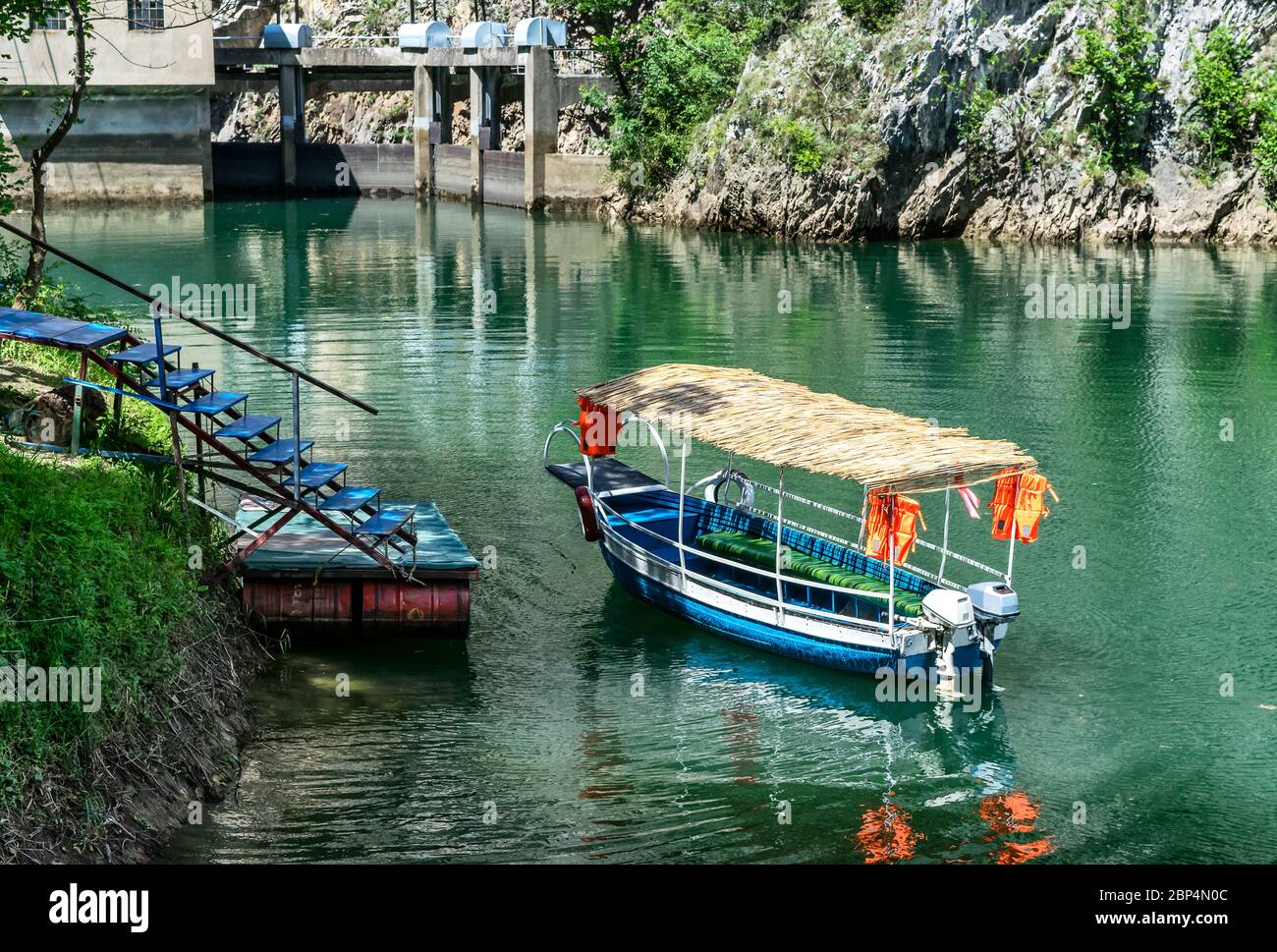 Transport von kleinen Touristen Blaues Boot dockte in der kleinen Bucht am Matka Canyon, Skopje, Mazedonien Stockfoto