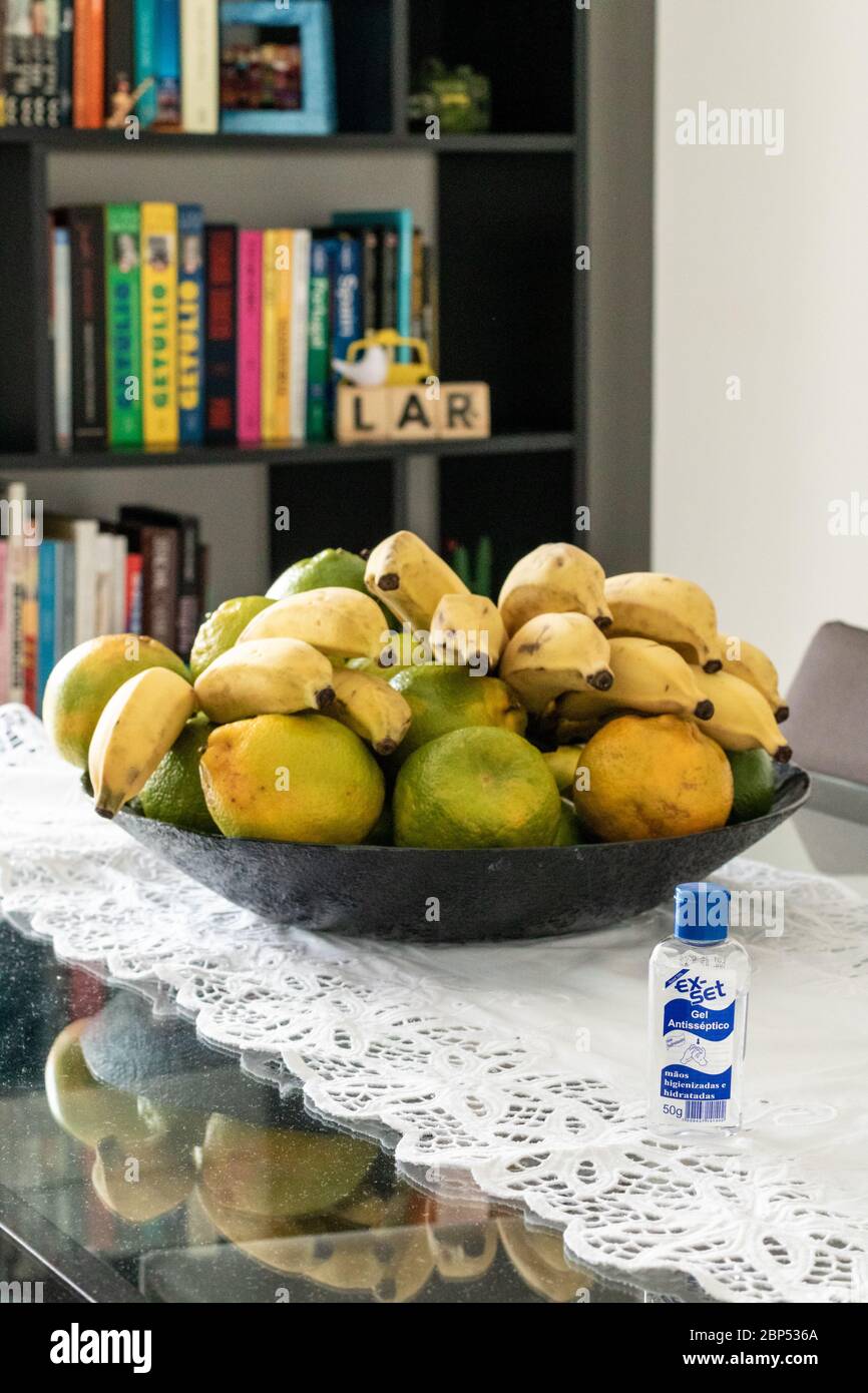 Obstkorb auf dem Wohnzimmertisch mit Büchern Der Hintergrund und Gel Alkohol Stockfoto
