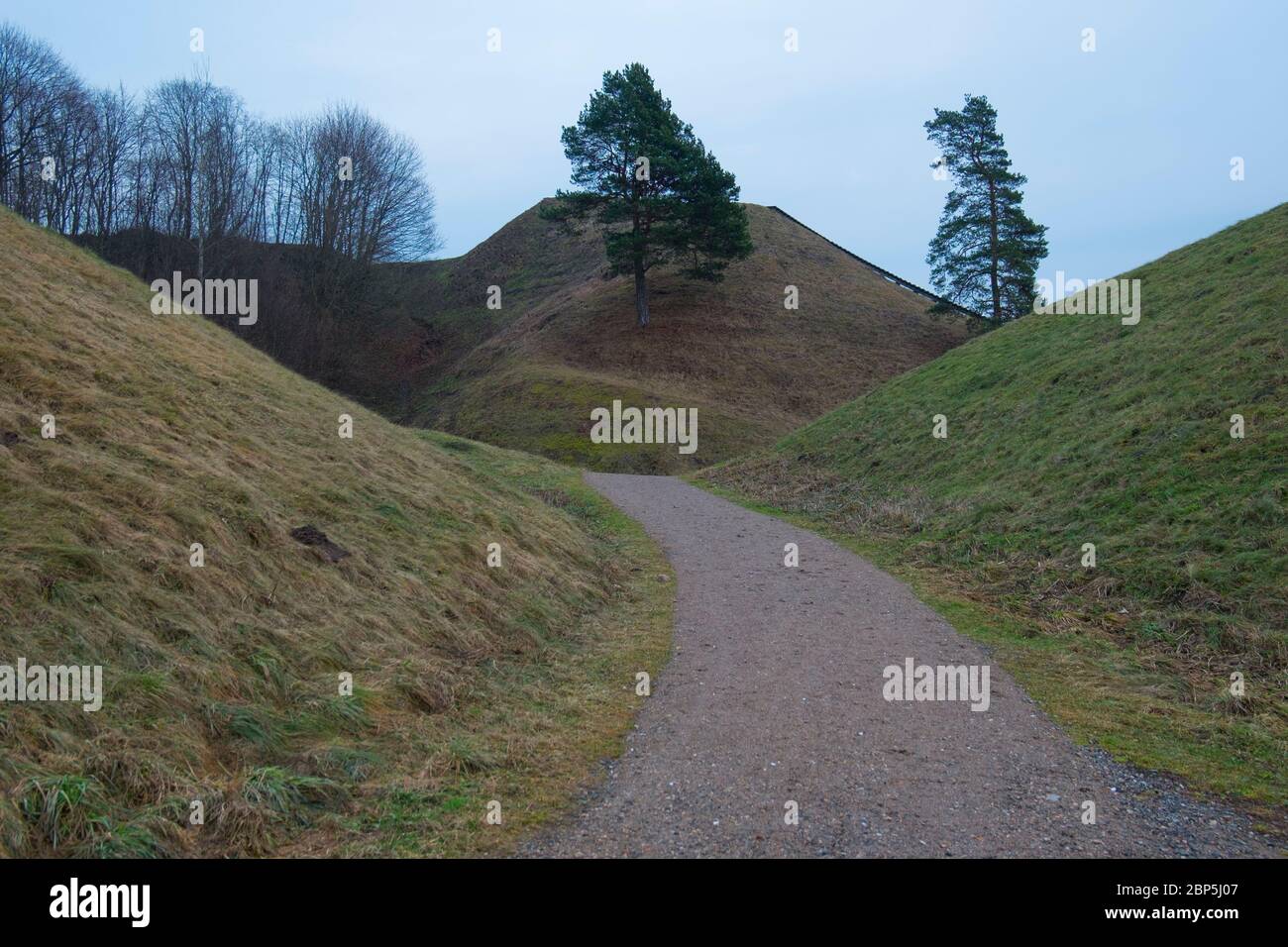 Ein Pfad windet sich zwischen den berühmten, alten, paläolithischen, Schmutz Hügel von Kernave. In Litauen im Winter. Stockfoto