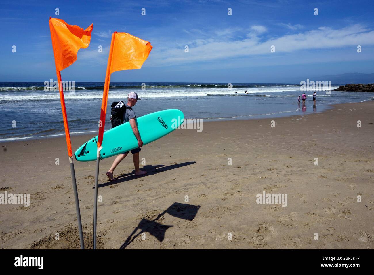 Ein Surfer spaziert am Strand entlang, während die Menschen am 17. Mai 2020 in Venice Beach in Los Angeles, Kalifornien, soziale Distanz aufrechterhalten. Los Angeles County öffnete seine Strände für den aktiven Gebrauch wieder, während die Menschen Gesichtsmasken tragen und soziale Distanz beibehalten müssen, während der Landkreis versucht, COVID-19 Infektionen zu reduzieren. (Foto von Ronen Tivony/Sipa USA) *** Bitte verwenden Sie das Guthaben aus dem Feld Guthaben *** Quelle: SIPA USA/Alamy Live News Stockfoto