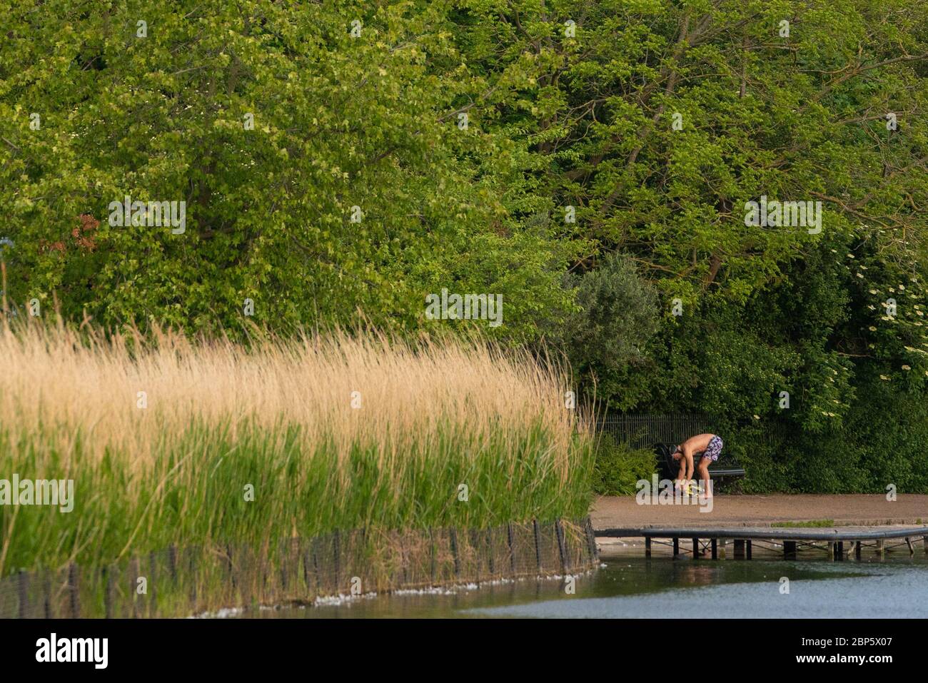 Ein Schwimmer wechselt draußen am Serpentine Lido im Hyde Park, London, und öffnet sich nach der Lockerung der Lockdown-Maßnahmen des Coronavirus für Mitglieder des Serpentine Swimming Club. Stockfoto