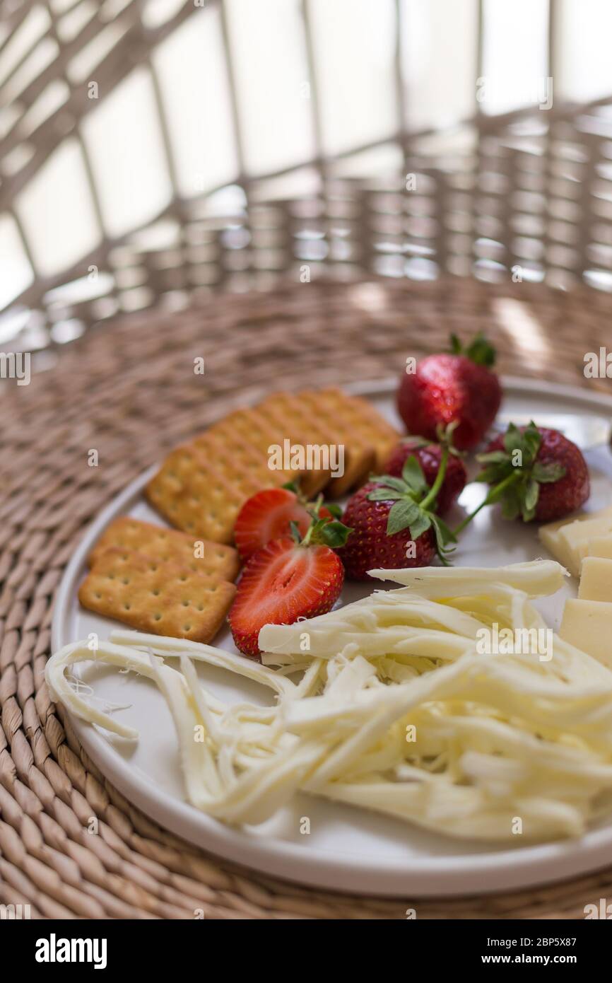 Vertikale Abbildung der Käseplatte mit Erdbeeren und Crackern. Stockfoto