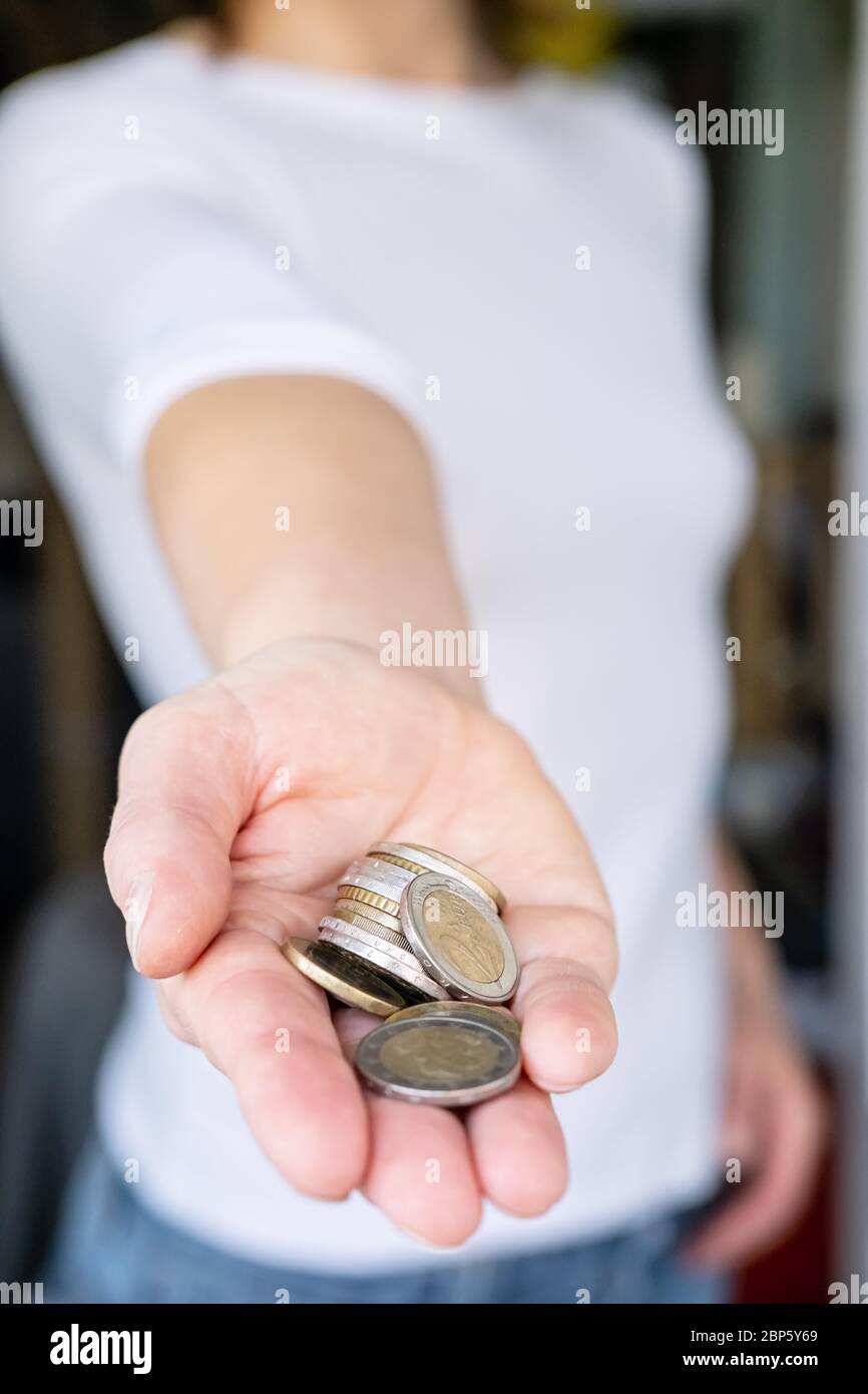 Kleiner Haufen Münzen in einer weiblichen Hand. Konzept der Krise und Geld sparen. Stockfoto