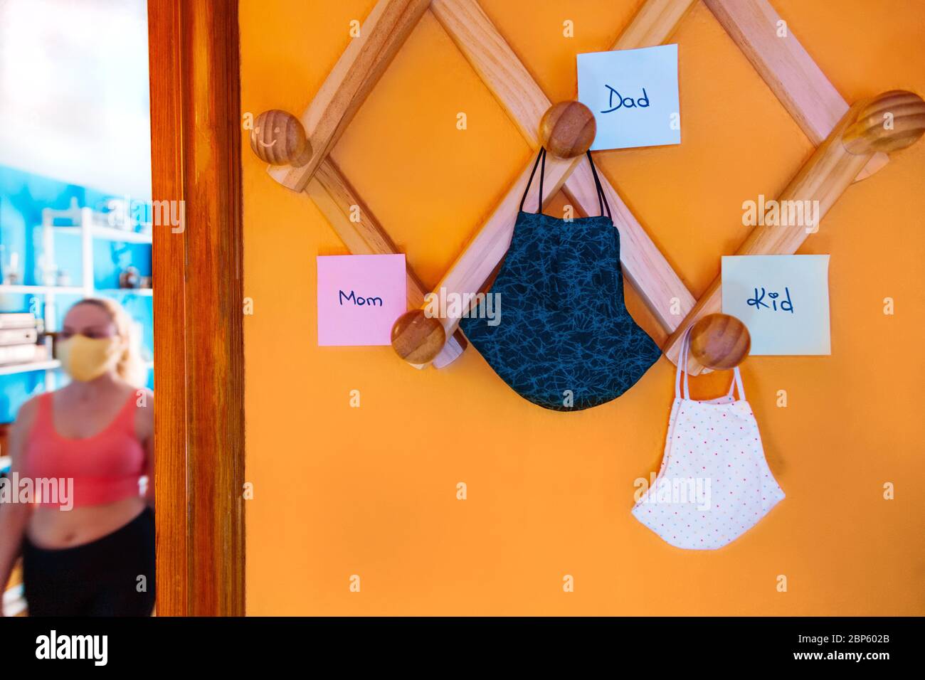 Chirurgische Masken der Familie hängen an der Garderobe mit Etiketten Stockfoto