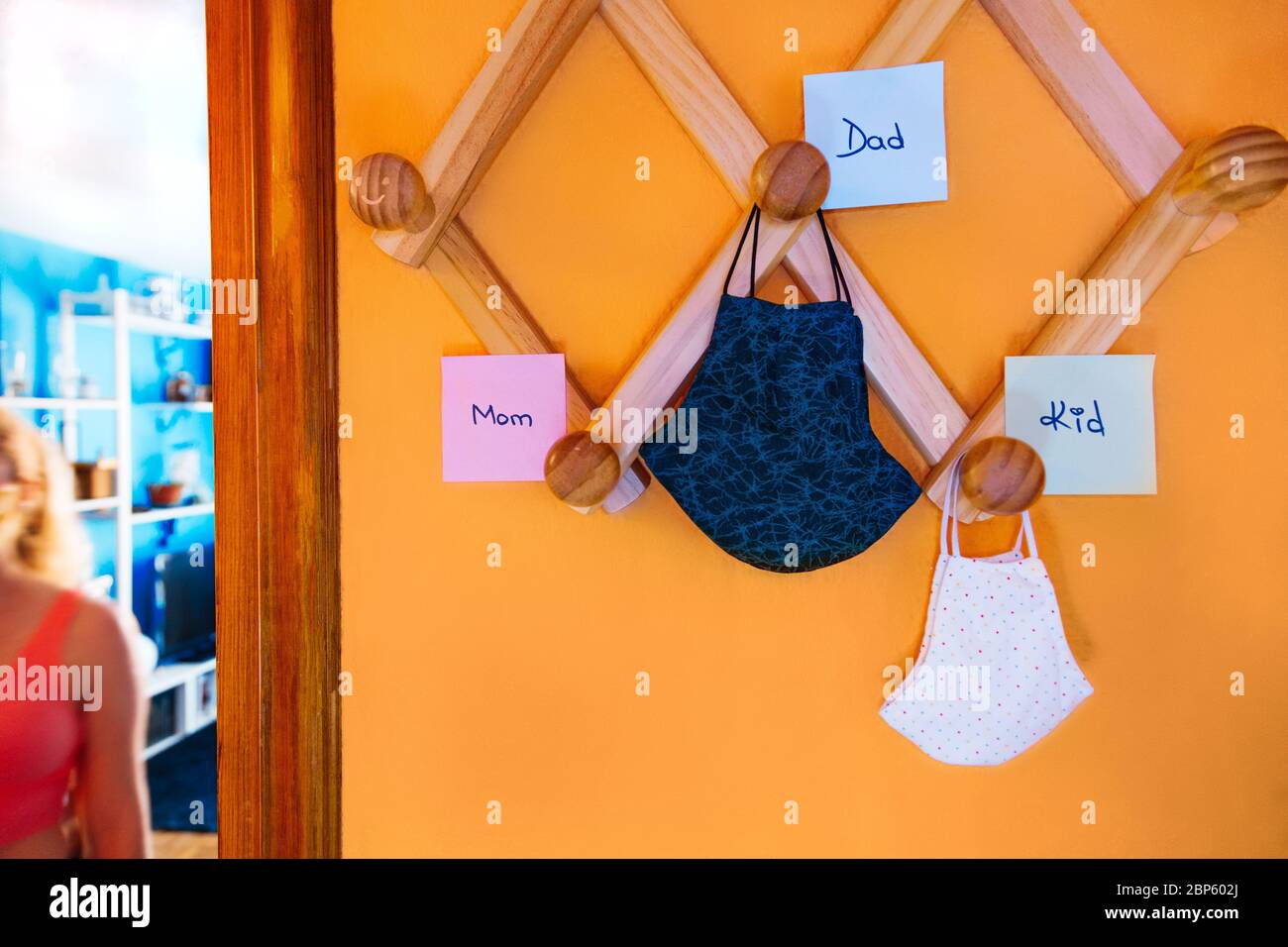 Chirurgische Masken der Familie hängen an der Garderobe mit Etiketten Stockfoto
