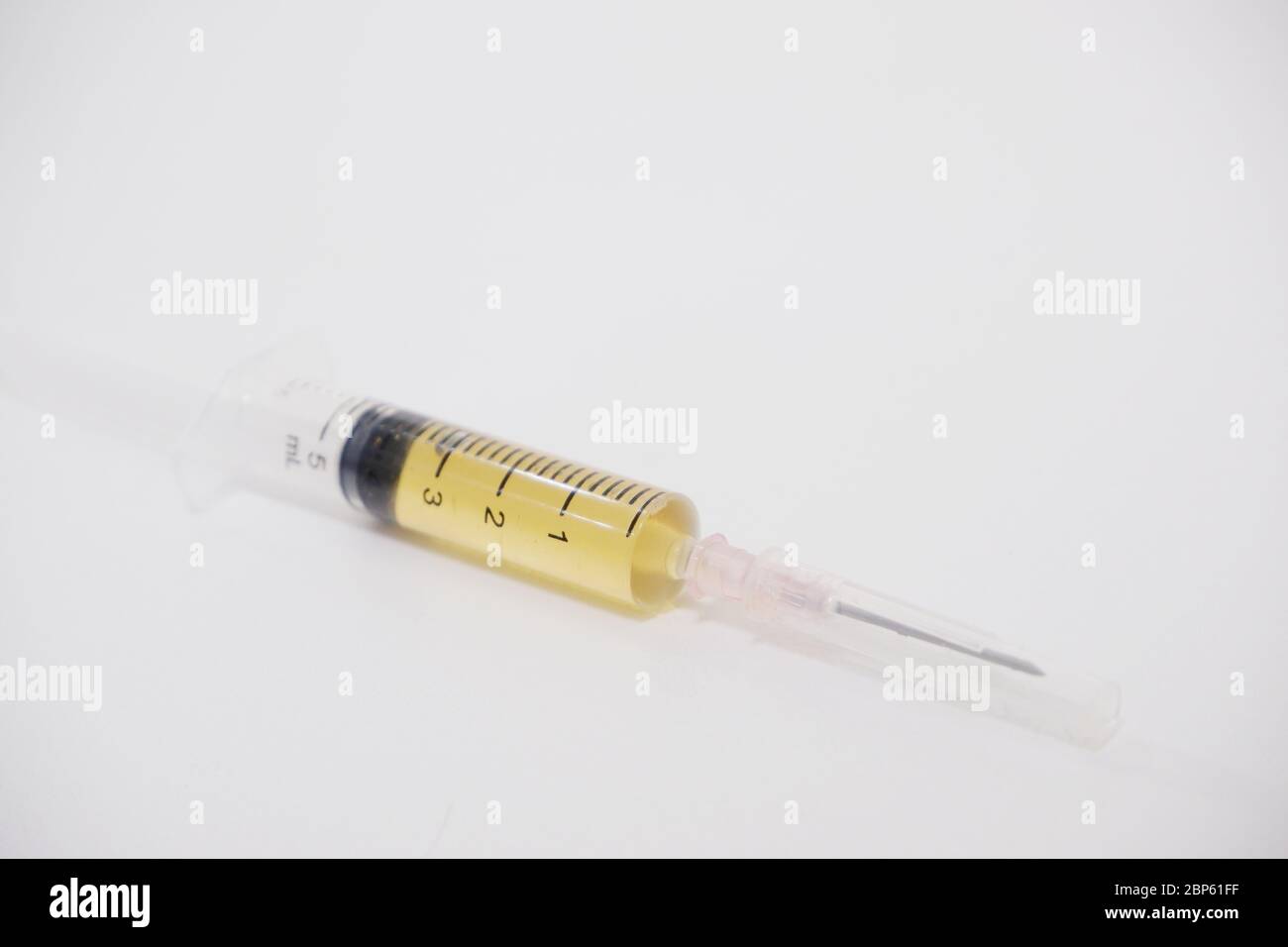 Die Nahaufnahme der Syring-Nadel enthält Impfstoff auf weißem Hintergrund. Stockfoto