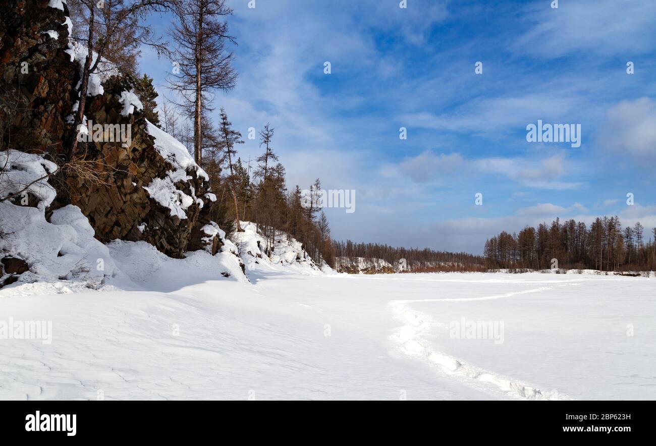 Winterlandschaft des Tschulman-Flusstal in Süd-Jakutien, Russland. Fußspuren im Schnee. Stockfoto