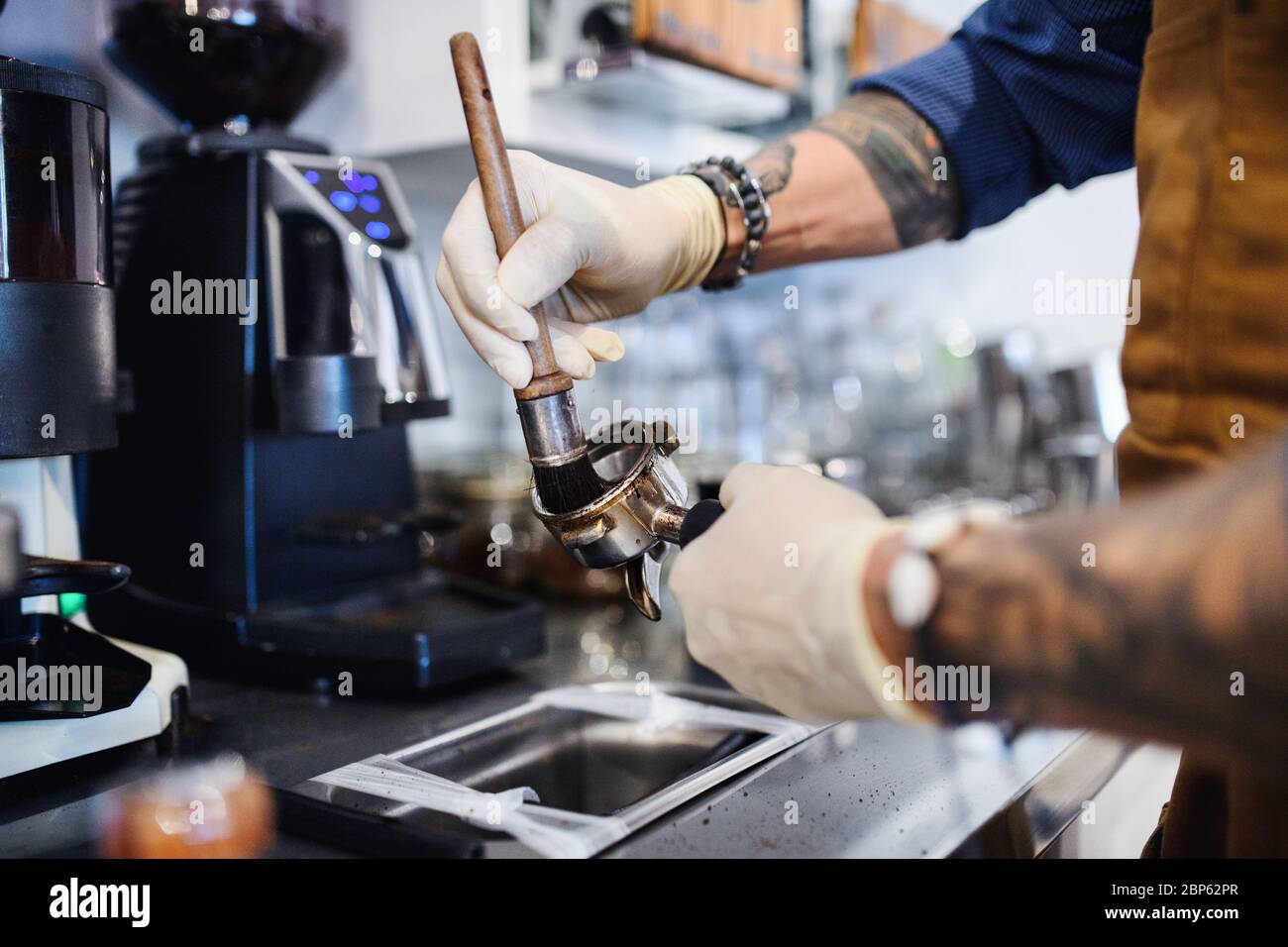 Barista arbeitet mit Handschuhen, Coffee Shop nach Sperrung Quarantäne geöffnet. Stockfoto