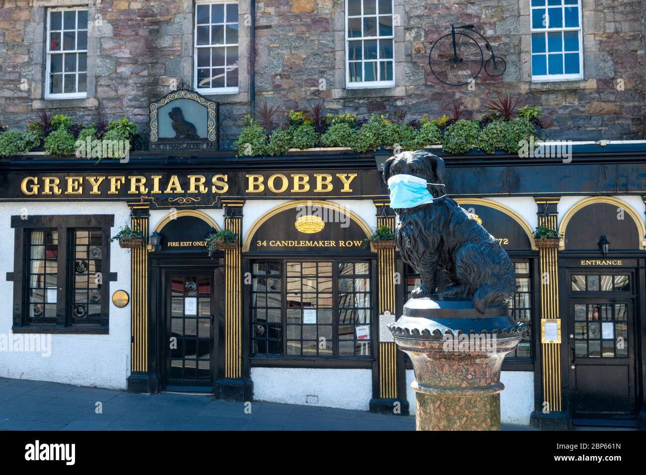 Statue von Greyfriars Bobby (mit Gesichtsmaske) außerhalb Greyfriars Bobby Pub während der Coronavirus-Pandemie - Candlemaker Row, Edinburgh, Schottland, Großbritannien Stockfoto