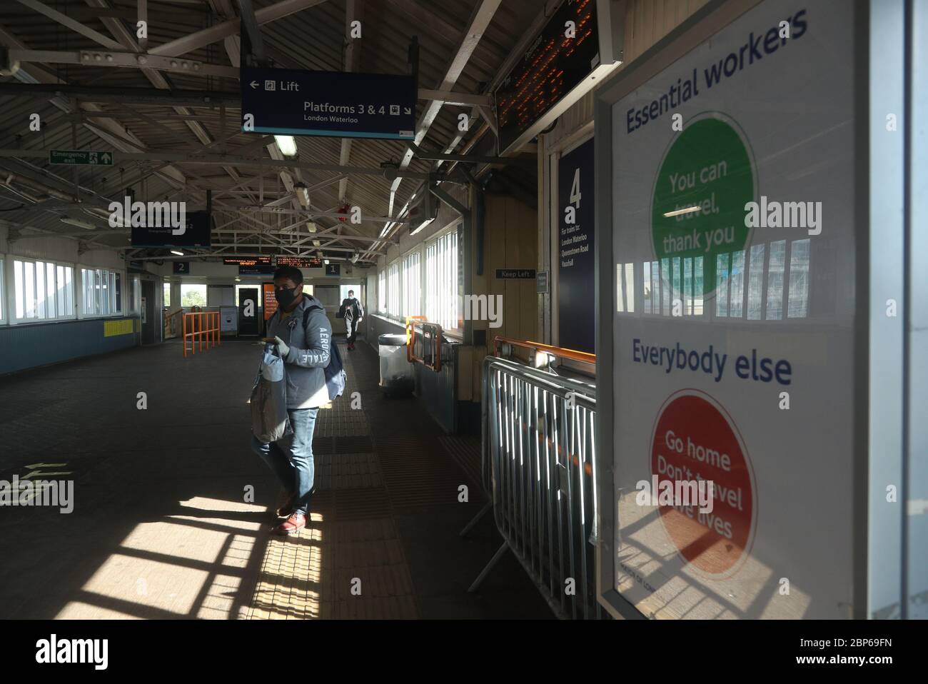 Ein Pendler in einer Gesichtsmaske am Bahnhof Clapham Junction in London, da die Zugverbindungen im Zuge der Lockerung der Beschränkungen der Sperrung durch Coronavirus zunehmen. Stockfoto