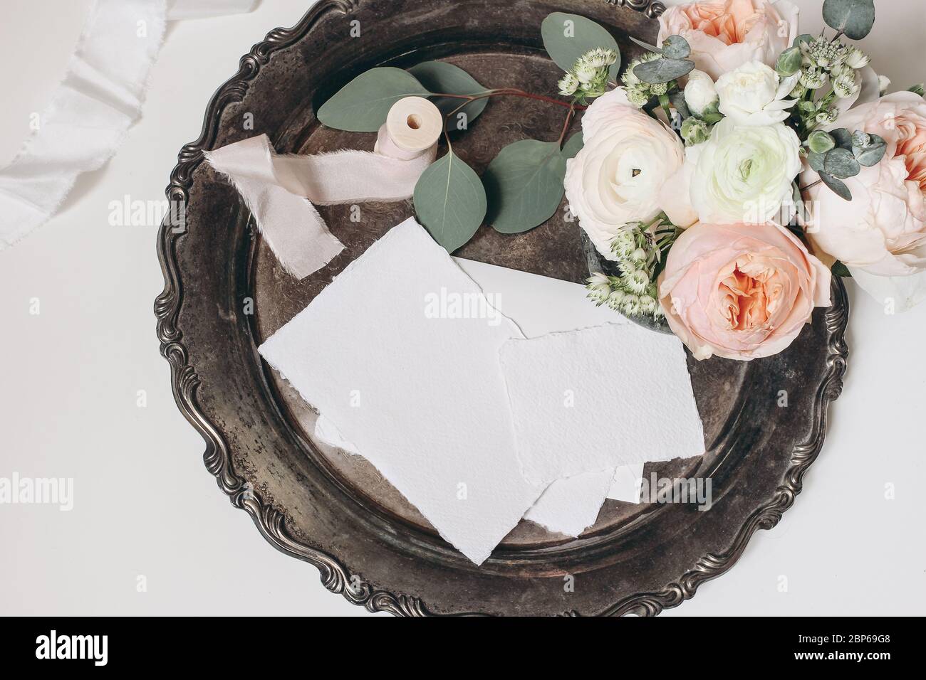 Hochzeit, Geburtstag Schreibwaren Stillleben. Bouquet von rosa englischen Rosen, Ranunculus und Astrantia Blumen, Eukalyptus und Seidenband auf Vintage-Silve Stockfoto