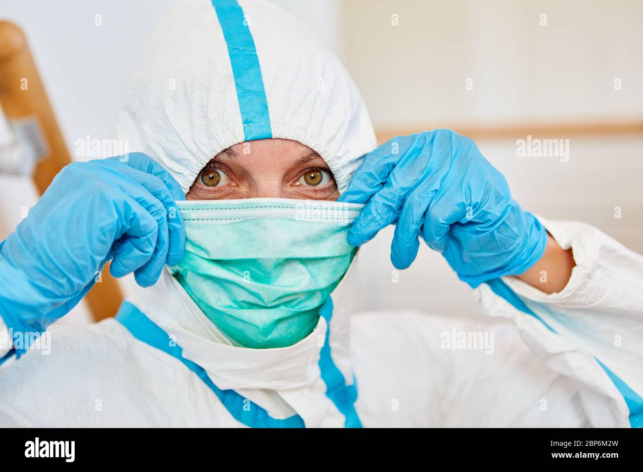 Krankenschwestern oder medizinische Fachkräfte, die Schutzkleidung tragen, setzten während der Covid-19-Epidemie neue Mundschutz an Stockfoto