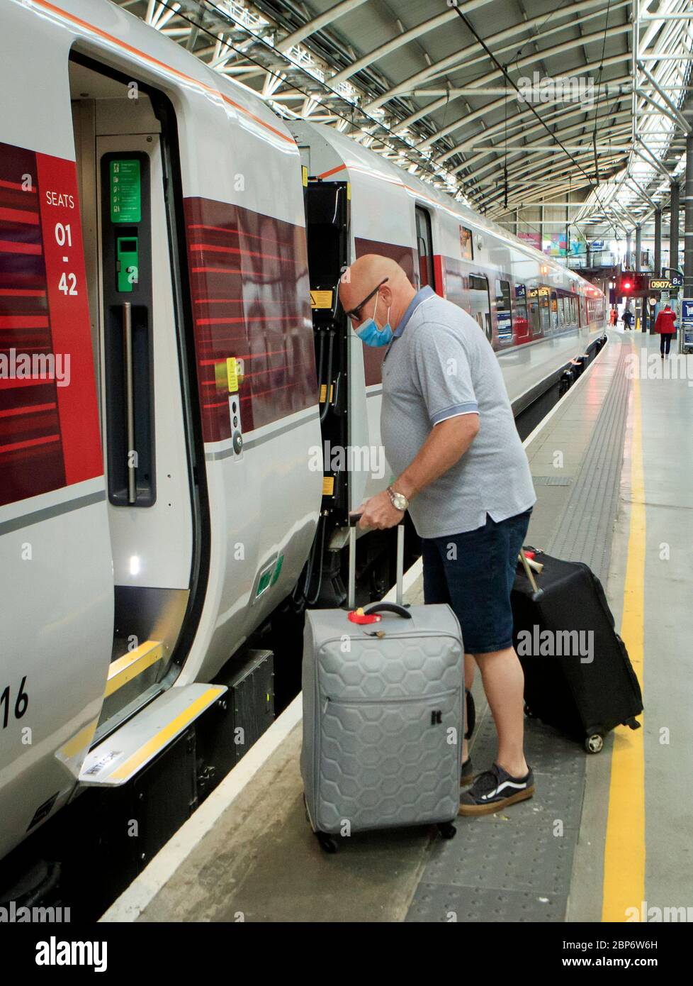 Ein Mann trägt eine Gesichtsmaske am Bahnhof Leeds, da die Zugverbindungen im Zuge der Lockerung der Beschränkungen für die Sperrung des Coronavirus zunehmen. Stockfoto