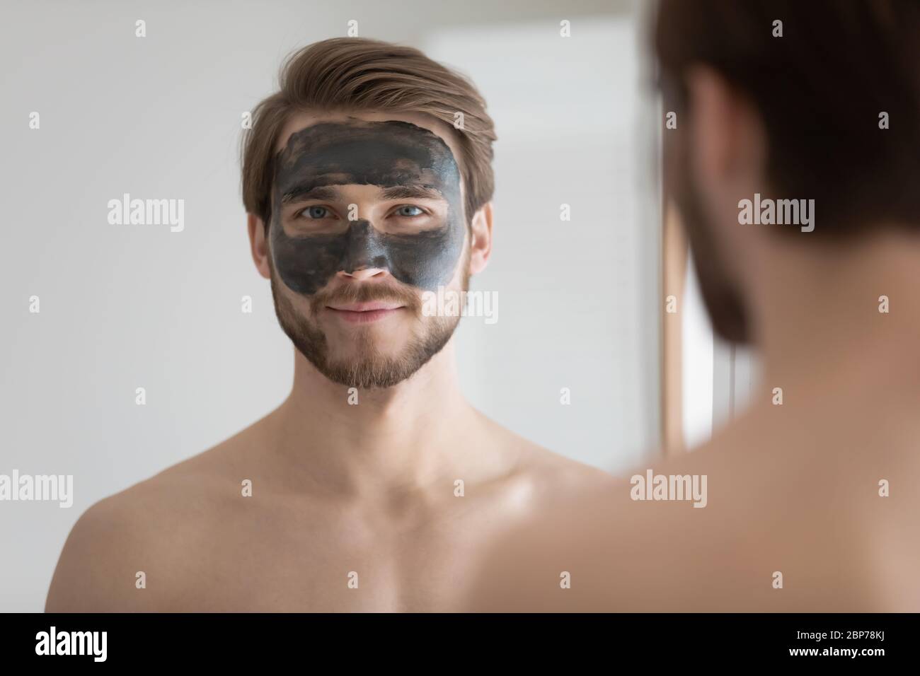 Portrait des jungen Mannes gelten Holzkohle Gesichtsmaske Stockfoto