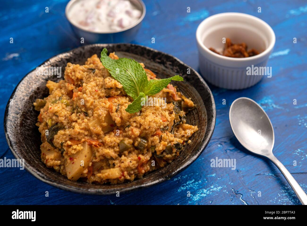 Indische Millets Biryani mit Raita und Pickle Stockfoto