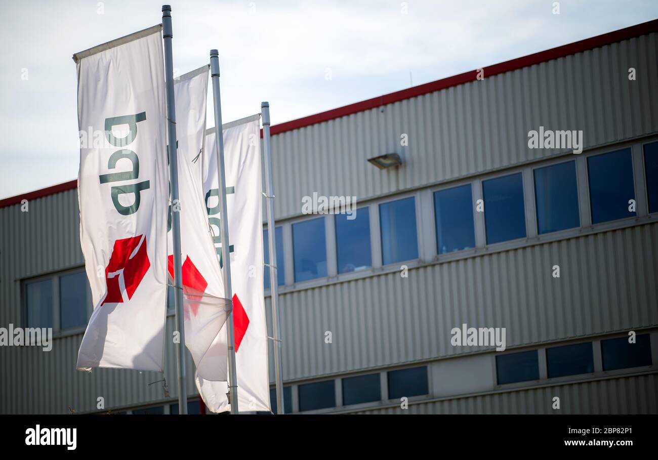 18. Mai 2020, Nordrhein-Westfalen, Hückelhoven-Hilfarth: Vor leeren Büros in den Räumlichkeiten des Paketzustellers DPD winken Fahnen mit dem DPD-Logo. Das Logistikunternehmen hat seinen Standort in Hückelhoven im Kreis Heinsberg mit 400 Mitarbeitern aufgrund eines Corona-Ausbruchs vorübergehend geschlossen. Foto: Jonas Güttler/dpa Stockfoto