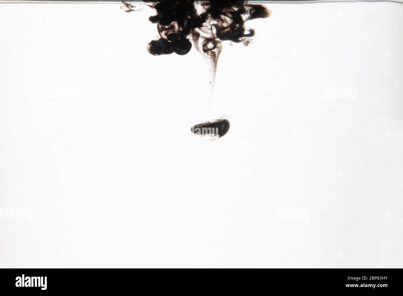 Ein schönes Bild einer schwarzen Flüssigkeit, die sich in Wasser mischt, abstraktes Muster Stockfoto