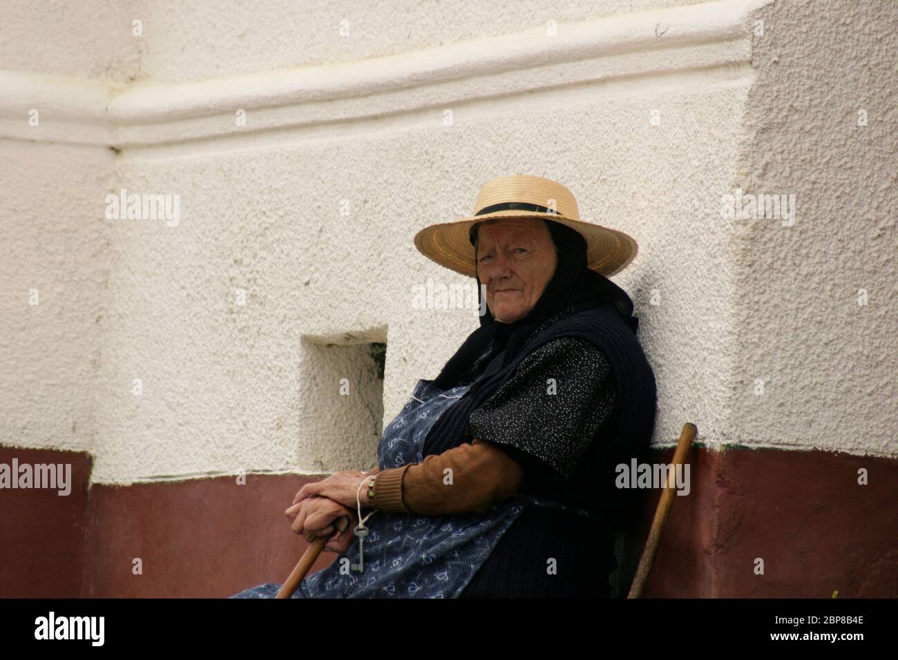 Sibiu County, Transylvania, Rumänien. Porträt einer älteren Frau, die auf einer Bank vor ihrem Haus sitzt. Stockfoto