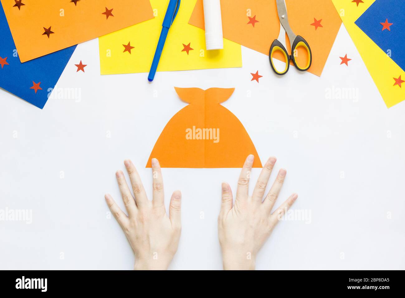 Wie einfach Papier Spaß Spielzeug Fisch mit Kindern zu Hause zu machen. Schritt 4. Legen Sie die ausgeklappte Figur mit dem Schwanz nach oben auf den Tisch Stockfoto