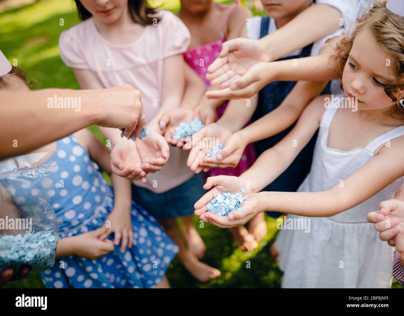 Unkenntlich kleine Kinder im Freien im Garten im Sommer, halten Konfetti. Stockfoto