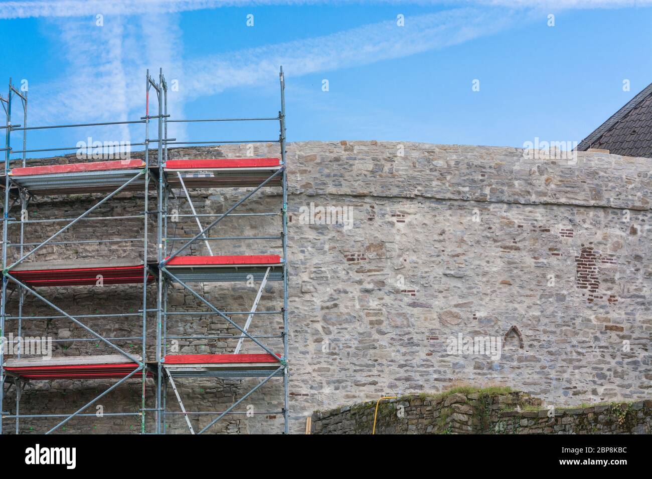 Alte Stadtmauer mit baugerüst vor blauen Himmel. Stockfoto