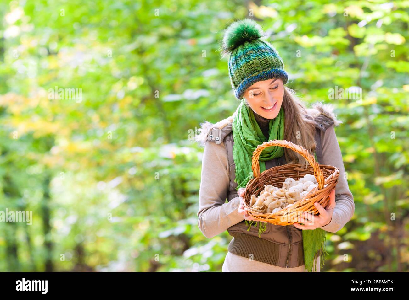 Frau mit Korb voller Champignons im Wald Stockfoto