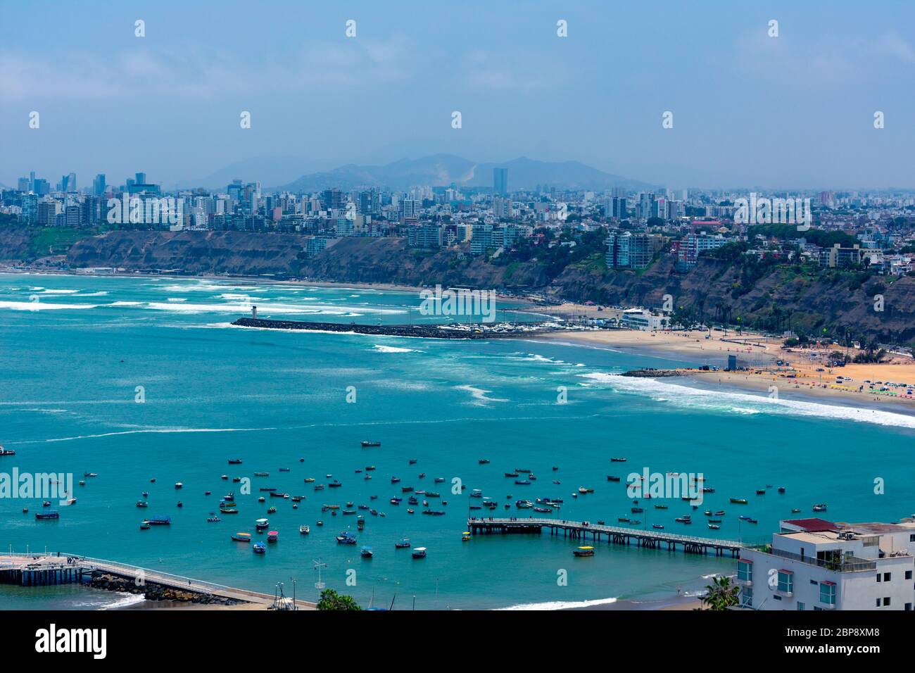 Luftaufnahme des Strandes in der Stadt Lima, Peru. Einige Docks und Boote auf dem blauen Meer Stockfoto