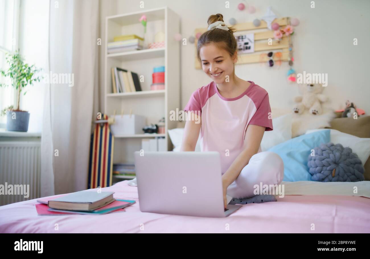 Junges Mädchen mit Tablet-Laptop auf dem Bett, während der Quarantäne entspannen. Stockfoto