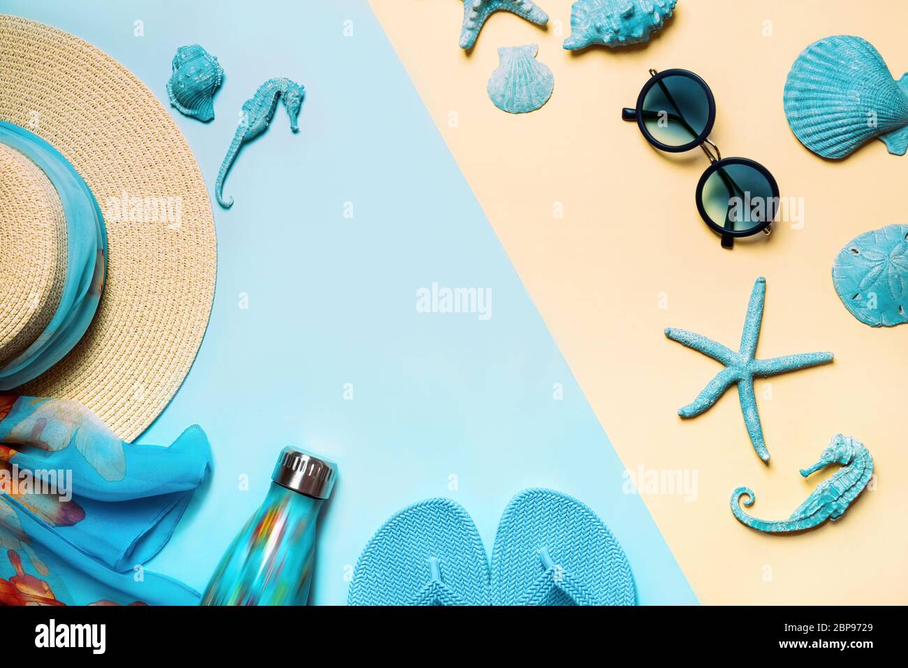 Sommer Mode auf blauem und korallenfarbenem Hintergrund. Blaue Flip Flops, Muscheln, Sonnenbrille, Flasche und Strohhut. Flaches Layout, Draufsicht mit Kopierfläche. Stockfoto