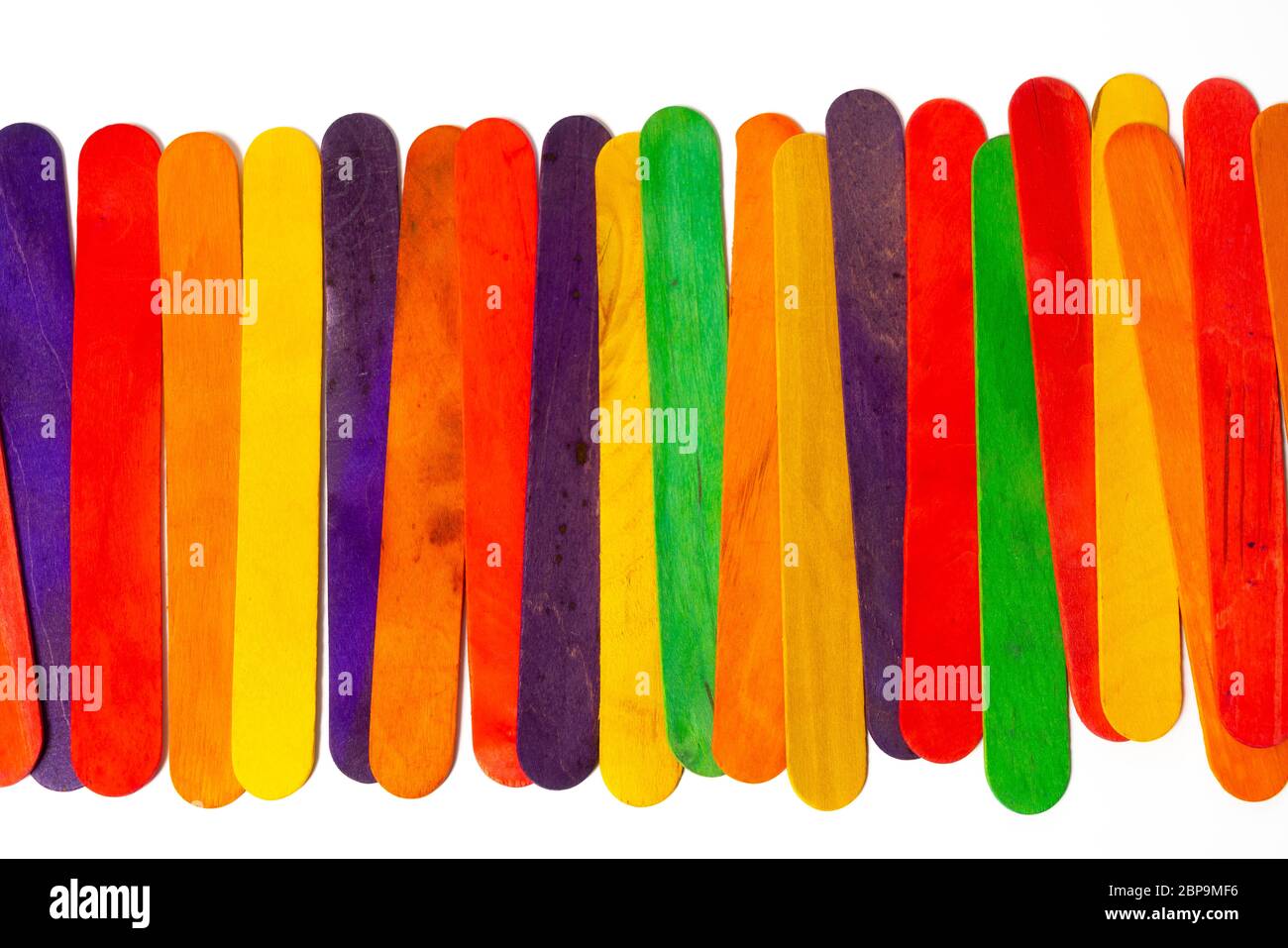 Einige farbige Holzlatten auf eine weiße Fläche angeordnet Stockfoto