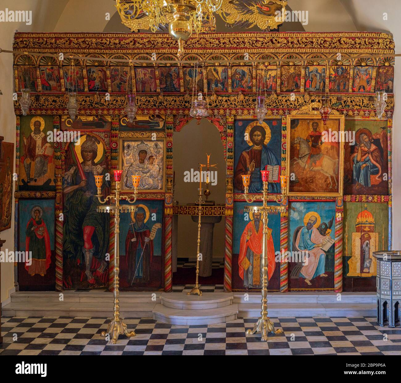 Betreten Sie eine der zahlreichen Kapellen in Santorini, um einen kunstvollen goldenen und bemalten Altar zu finden Stockfoto