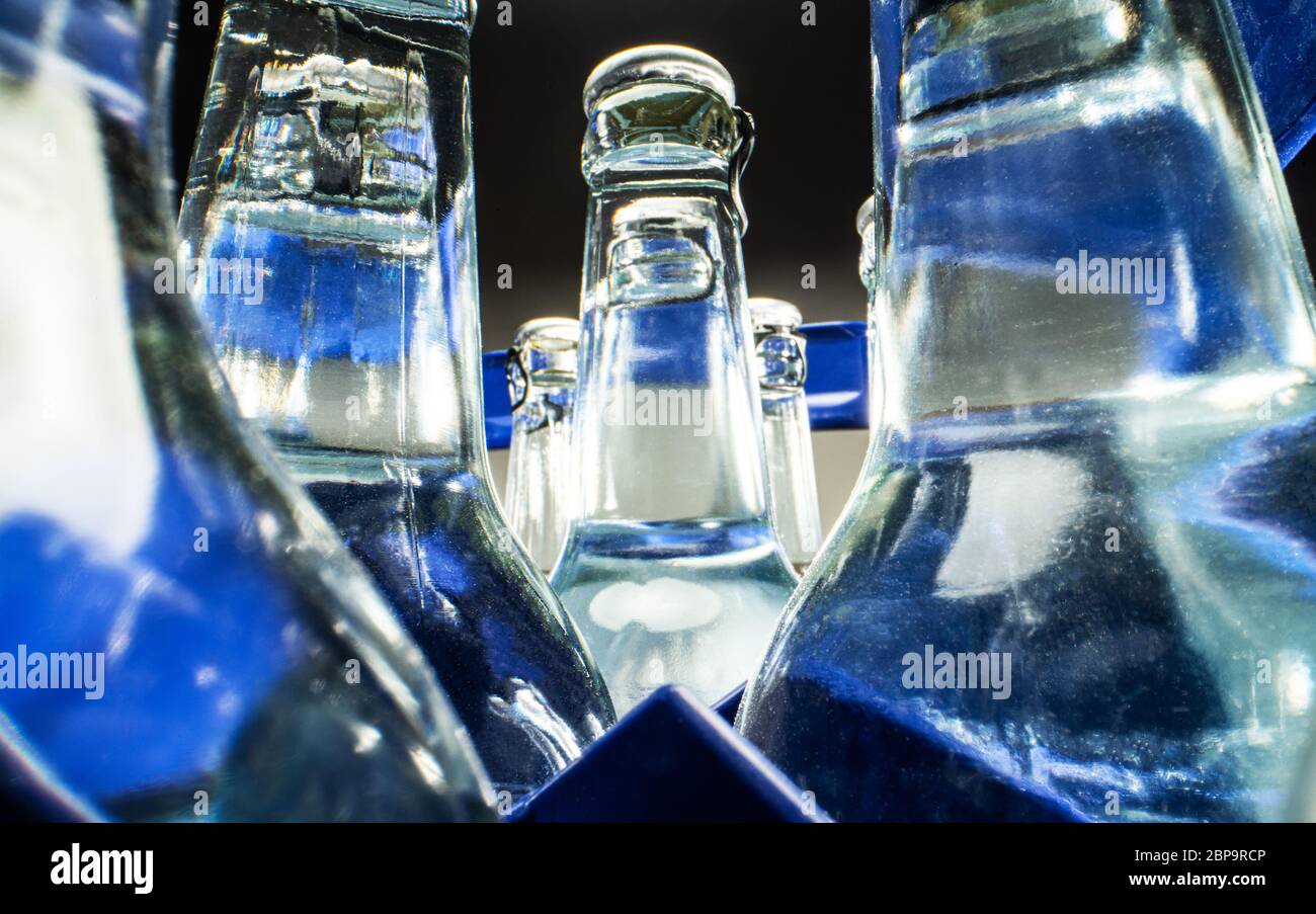Nahaufnahme Der Blauen Hülle Aus Durchsichtigen Glasflaschen, Die Mit Mineralwasser Gefüllt Sind. Stockfoto