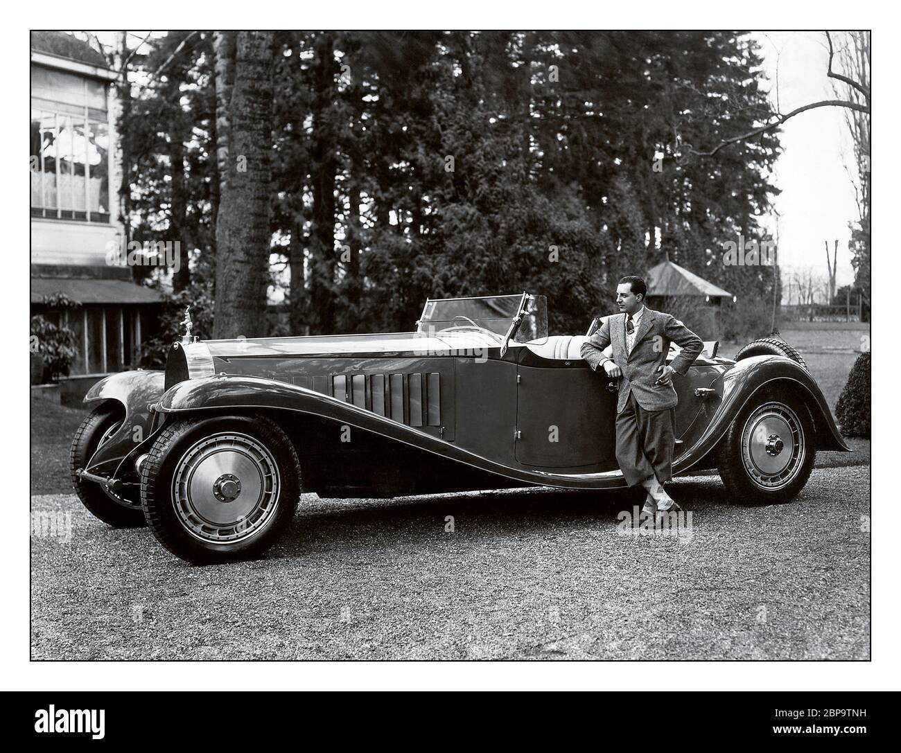 Vintage Bugatti Typ 41 Royale Esders Roadster, Archiv 1927 Jean Bugatti steht neben dem Bugatti Typ 41, besser bekannt als Royale, ist ein großer Luxuswagen von 1927 bis 1933 mit einem Radstand von 4.3 m (169.3 in) und einer Gesamtlänge von 6.4 m (21 ft). Er wiegt ca. 3,175 kg (7,000 lb) und verwendet einen 12.763-Liter-Motor (778 Cu in) mit acht Liter Hubraum. Das Royale ist eines der größten Autos der Welt. Jean Bugatti war französischer Automobildesigner und Testingenieur. Der in Köln geborene Gianoberto Maria Carlo Bugatti war der älteste Sohn von Ettore Bugatti. Stockfoto