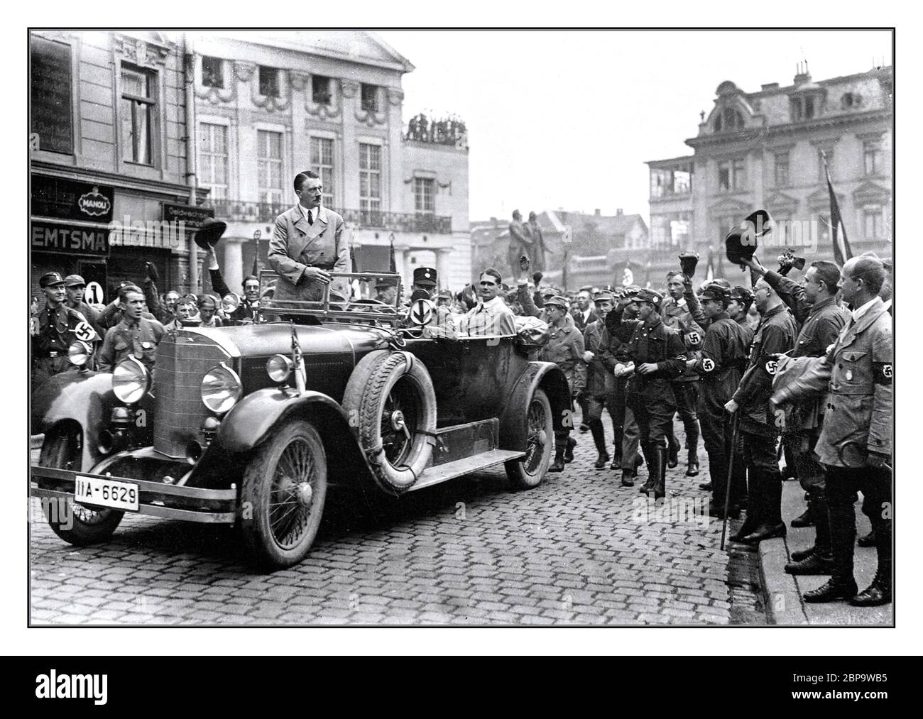 Adolf Hitler 1920er-Kundgebung NSDAP-Vorwahlversammlung in Weimar Deutschland 3.–4. Juli 1926, Hitler in Zivilkleidung stehend in seinem offenen Mercedes-Limousine-Wagen mit Rudolf Hess im Heck des Autos. Verschiedene Hakenkreuz Armband trägt Anhänger jubelnden seine Ankunft Stockfoto