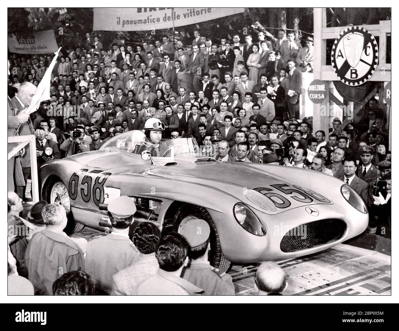1955 Mercedes-Benz 300 SLR mit Juan Manuel Fangio beim Start der Mille Miglia in Italien Dieses Rennen gewann Mercedes-Benz Werksfahrer Stirling Moss mit Hilfe seines Navigators Denis Jenkinson. Sie absolvierten die 992-Meilen-Distanz in 10 Stunden, 7 Minuten und 48 Sekunden – eine Durchschnittsgeschwindigkeit von 99 km/h (160 mph). Die beiden Engländer endeten 32 Minuten vor ihrem zweitplatzierten Teamkollegen Juan Manuel Fangio. Die Route basierte auf einer Rundreise zwischen Brescia und Rom, mit Start/Ziel, in Brescia Stockfoto