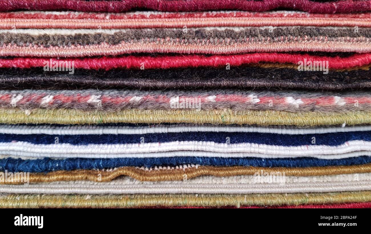 Haufen von alten türkischen Teppichen. Schichten von bunten Teppichen. Gewebte Textur. Kanten von ethnischen Teppichen. Traditionelle asiatische Fußmatten. Türkischer Basar Backdro Stockfoto