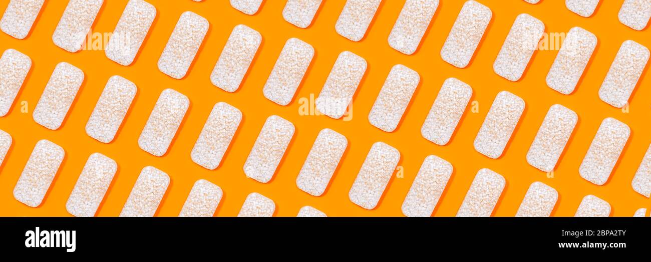 Muster aus Reiscrackern oder Reiskuchen auf orangefarbenem Hintergrund. Gesunde Bio-Lebensmittel. Flaches Lay. Stockfoto
