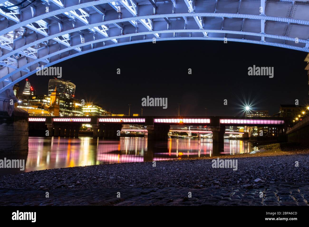 Southwark Bridge bei Nacht von unten zeigt neue Beleuchtung, alte Pflasterung und Cannon Street Bridge im Hintergrund. Stockfoto