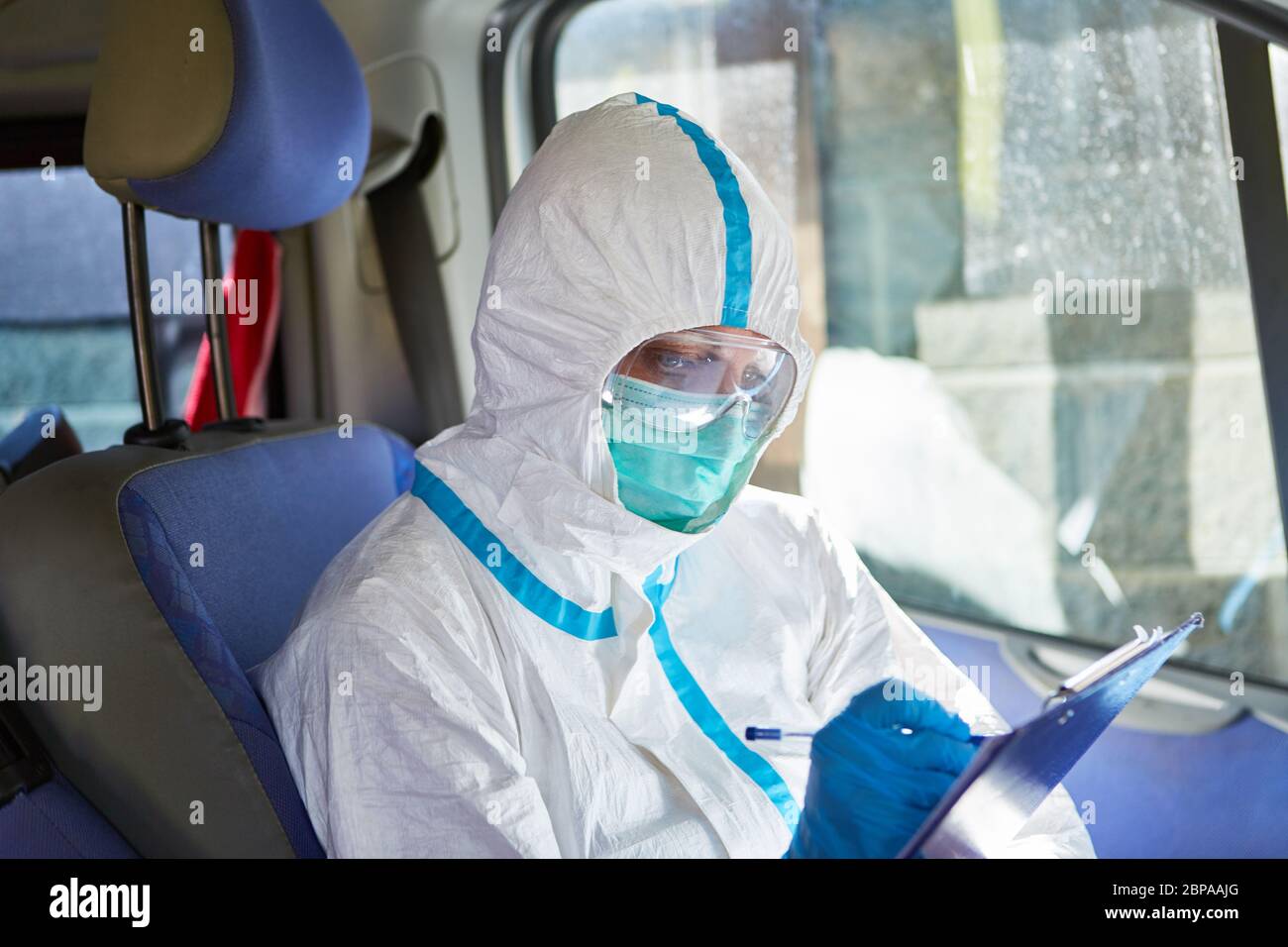 Sanitäter als Containment Scout studiert die Kontaktaufspürungsliste im Krankenwagen während einer Coronavirus-Pandemie Stockfoto