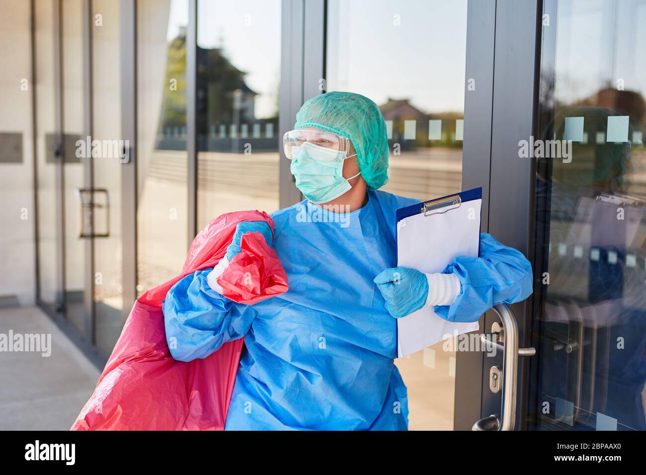 Reiniger bei der Kontrolle der Entsorgung gefährlicher Abfälle in der Klinik während der Coronavirus-Pandemie Stockfoto