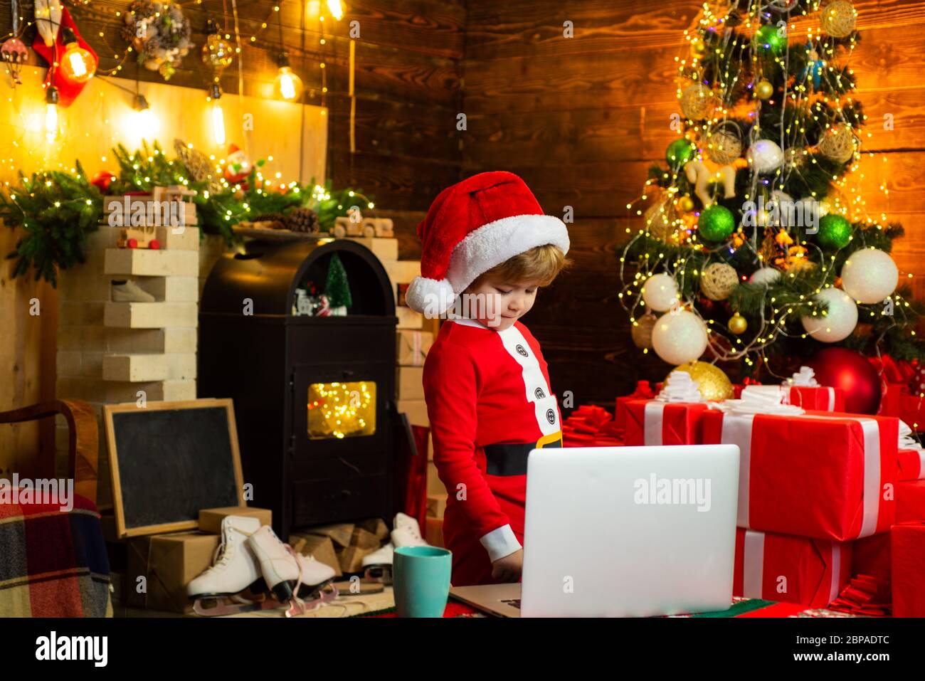 Urlaubsrabatte. Weihnachten. Kleiner Weihnachtsmann Helfer Elfe mit einem magischen Geschenk für Weihnachten. Überprüfen Sie den Inhalt des weihnachtsstrumpfs. Familie mit Kindern ce Stockfoto