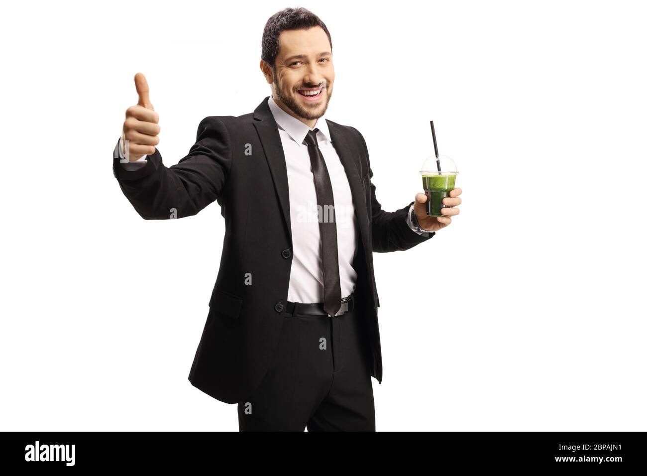 Geschäftsmann zeigt Daumen hoch und lächelt mit einem gesunden grünen Smoothie in der Hand isoliert auf weißem Hintergrund Stockfoto