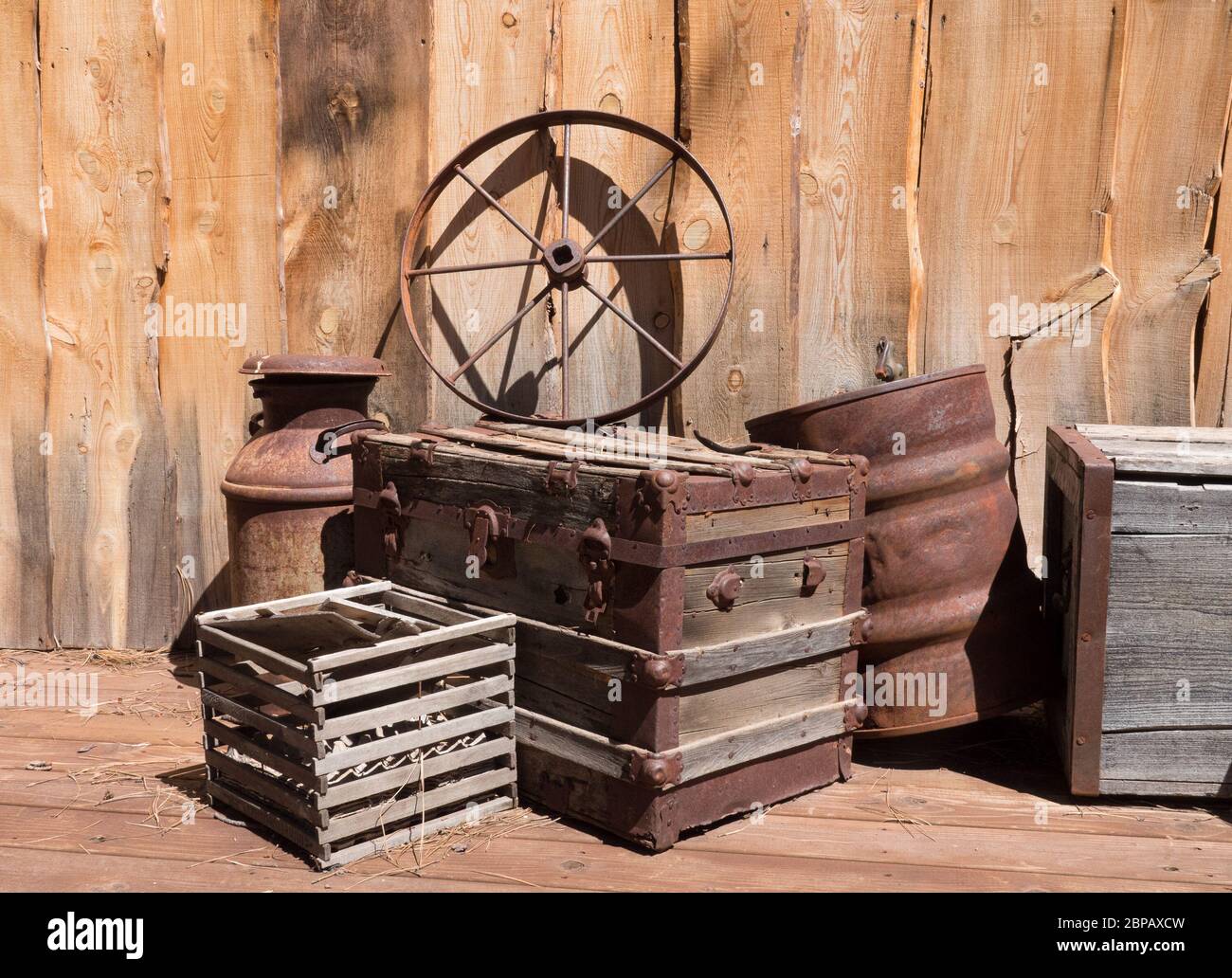 Altes Wagenrad auf einem alten Holzkoffer. Stockfoto